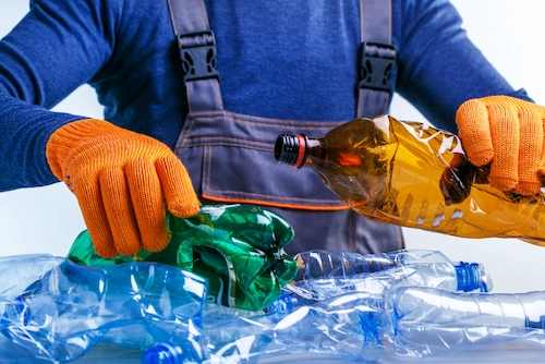 Seorang pekerja memilah sampah plastik untuk didaur ulang