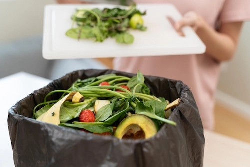 Orang membuang sampah makanan ke tempat sampah