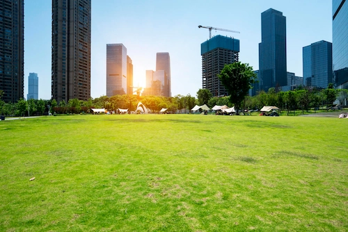 Area rumput dan gedung perkantoran yang tampak asri pada perkotaan yang mengusung konsep kota hijau