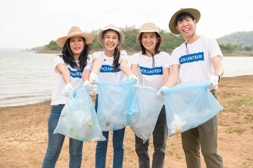 Volunteer membersihkan sampah di area pantai